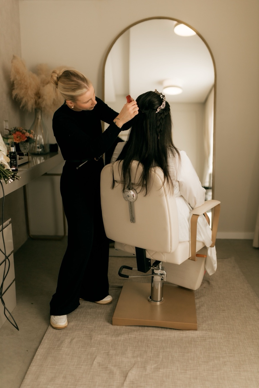 A local salon stylist doing bridal hair styling for a customer